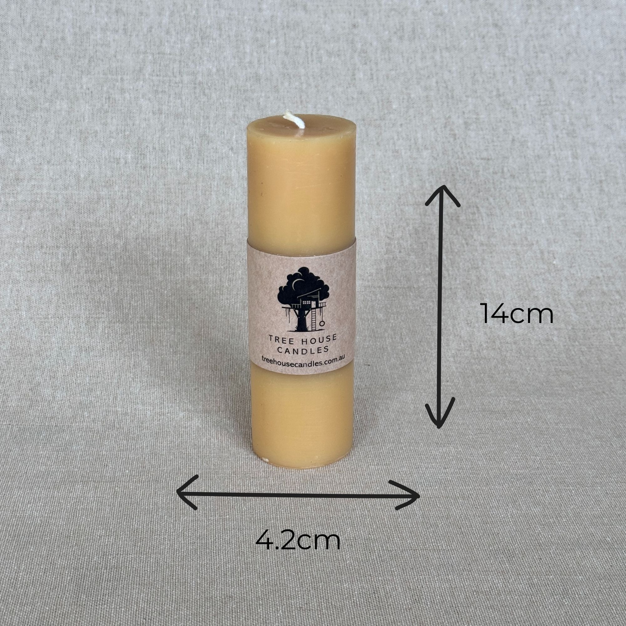 Beige candle with a label on a gray background, showing dimensions.