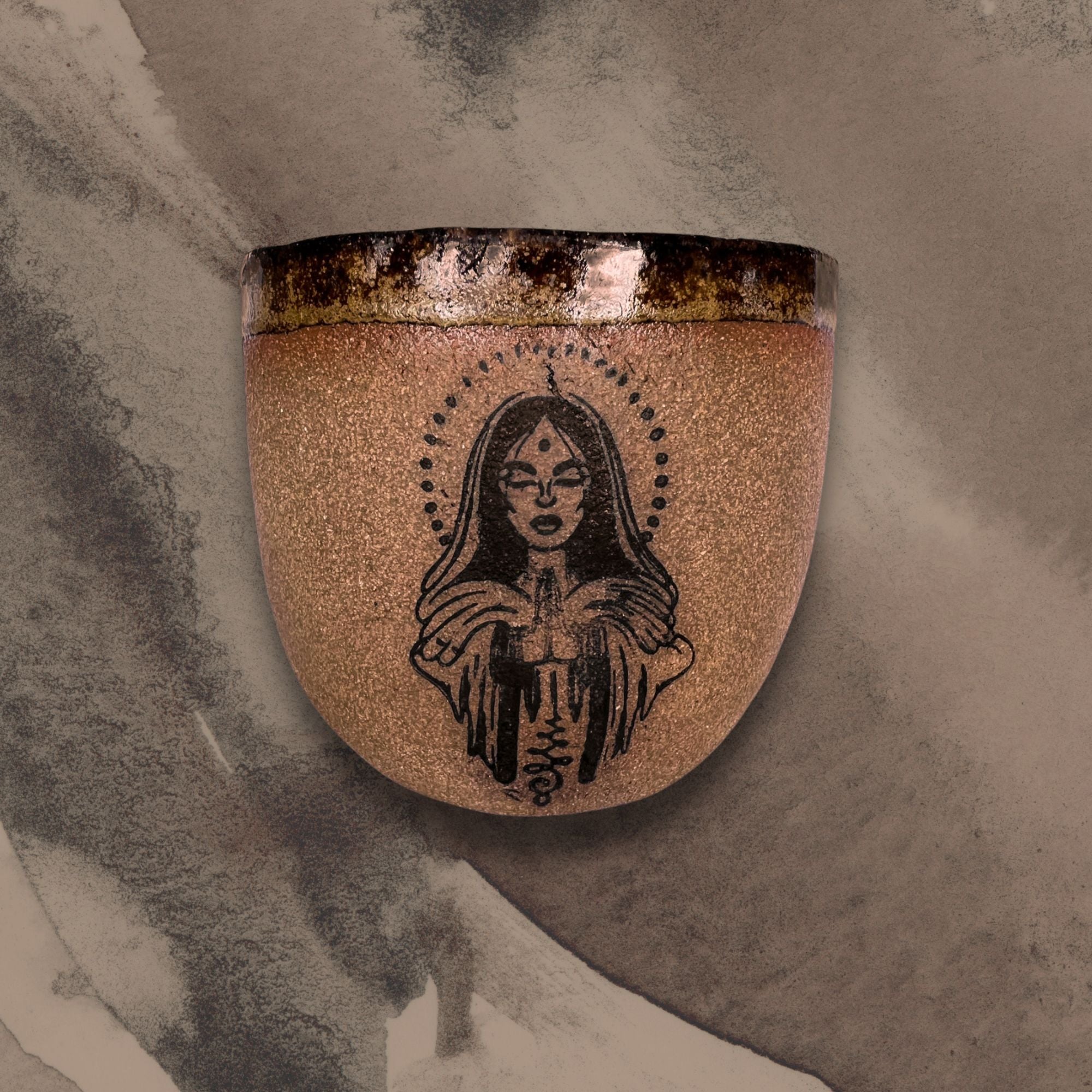 Ceramic wall art piece with a stylized face design on a textured surface