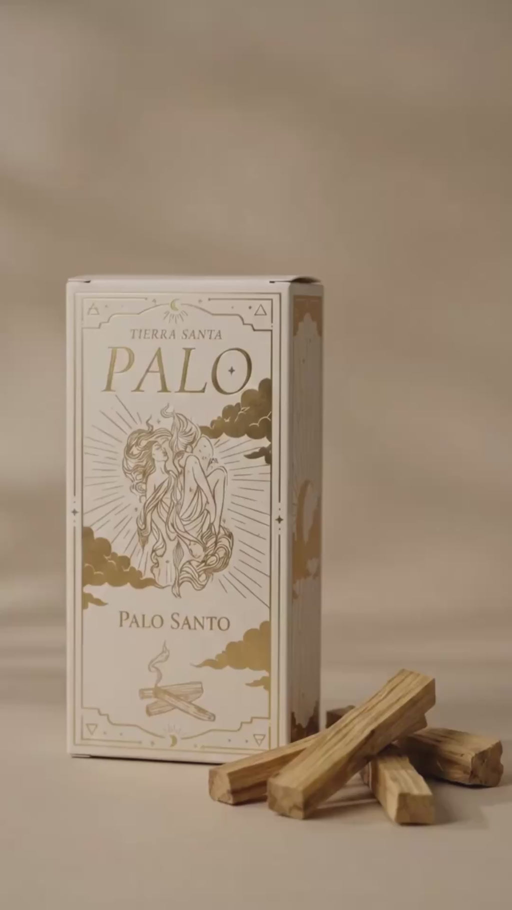 video of packaging of palo santo, showing a hand come into frame and showing a stick of palo santo that is lit by candle light, blown out, and the smudging smoke of the incense is shown