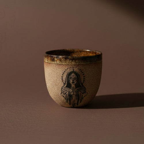 Ceramic cup with a face design on a brown background